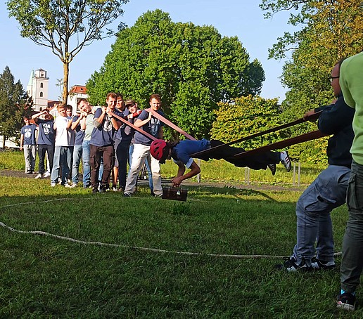 Students play on a meadow on campus.