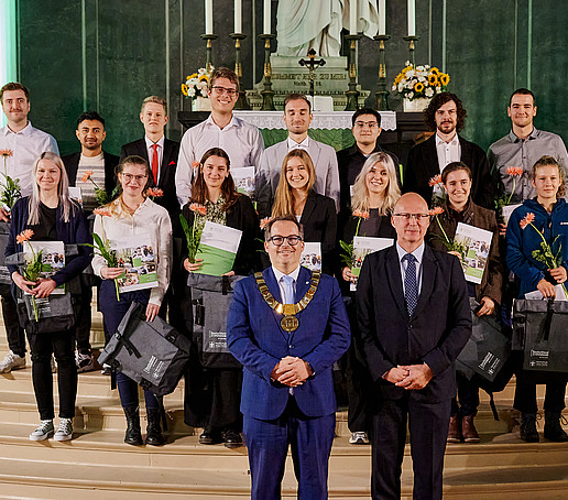 Group photo with the Rector, the Chairman of the University Council and the Deutschlandstipendium scholarship holders. They are standing on the steps of the altar.