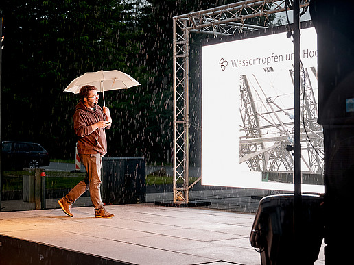 Prof. Weber auf der Bühne vor einer LED-Leinwand