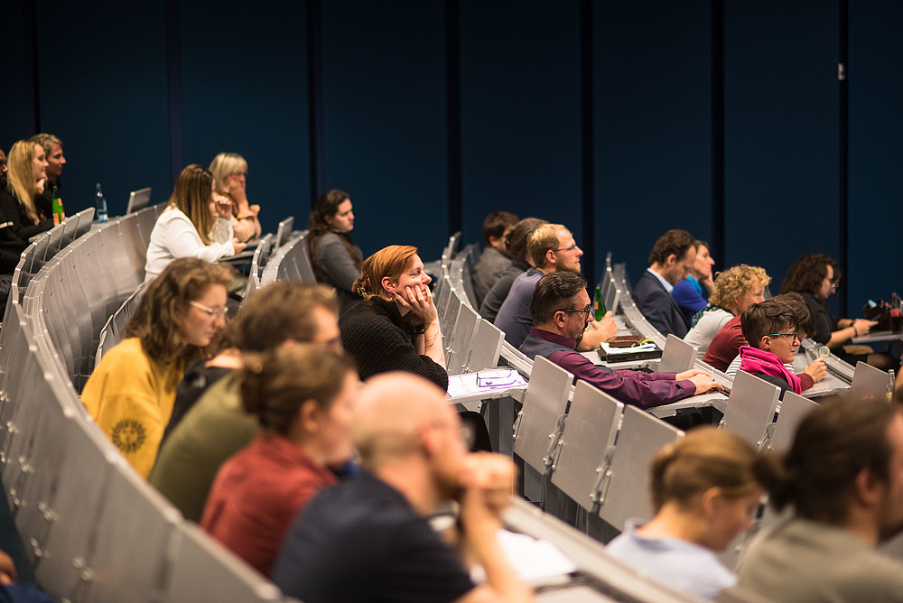 Many seats are filled in a lecture hall.